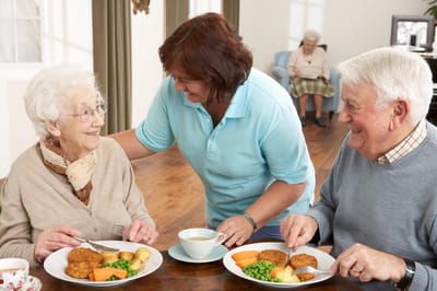 Residents enjoying a meal with staff assistance