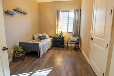 Cozy interior of a resident room with bed and chair
