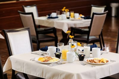 Dining table set for breakfast with food and drinks