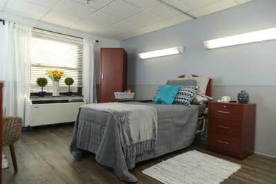 Brightly decorated resident room with a bed and furnishings
