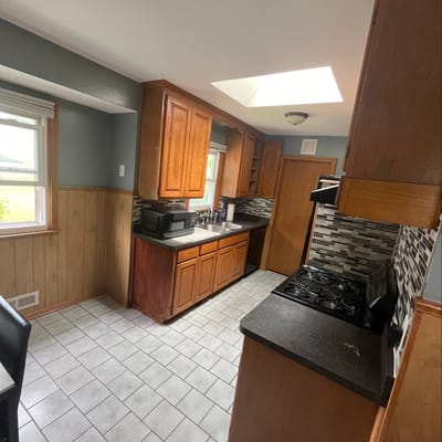 Bright kitchen with wooden cabinets and tile floor