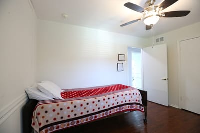 Bright resident room with a single bed and ceiling fan
