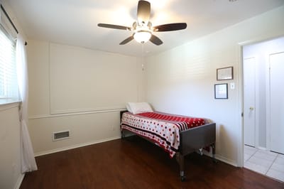 A private bedroom with a red and white patterned blanket