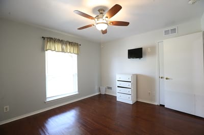 Cozy resident room with a ceiling fan and furnishings