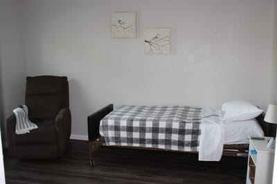 A furnished senior living room with a bed and recliner