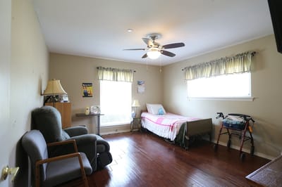 A private resident room with a bed and seating area
