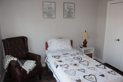 Cozy private room with a bed and chair