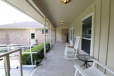 Covered porch area with rocking chairs and planters