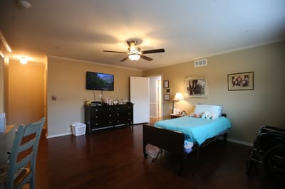 A private room with bed and furniture in a senior living facility