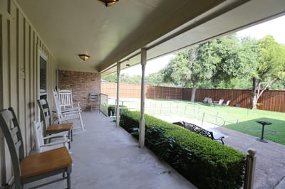 Porch with rocking chairs overlooking a green space