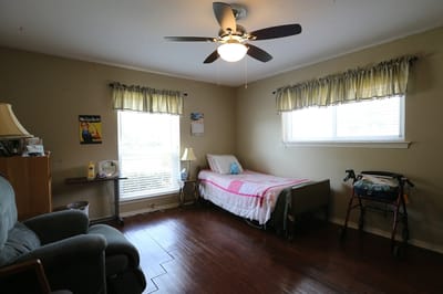A private resident room with a bed and seating area