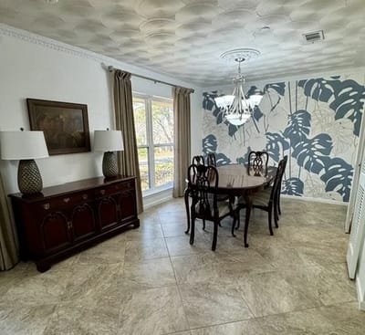 Elegant dining room with chandelier and decorative wall