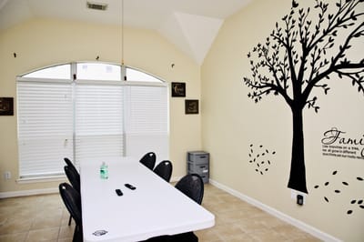 Common area with a long table and tree wall decal
