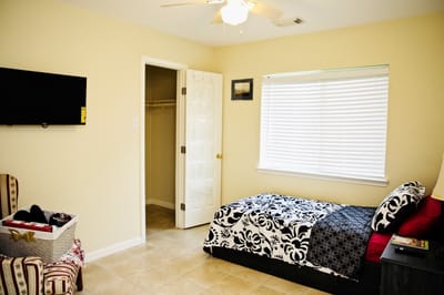 A cozy resident room with bed and chair