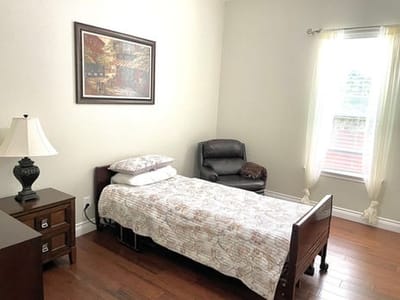 Bright private room with bed and armchair