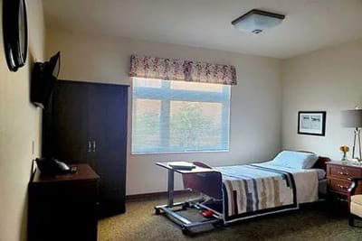 Well-furnished resident room with a bed and television