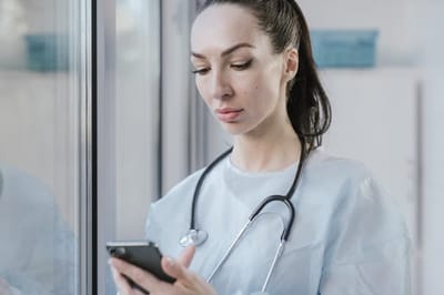 Healthcare worker using a smartphone in a facility