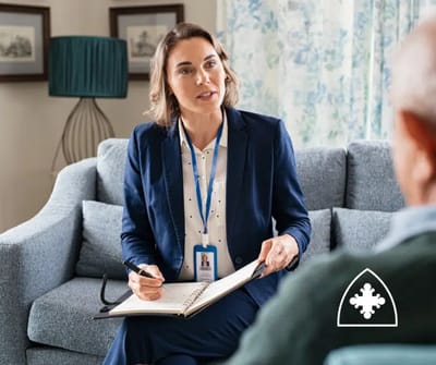 Staff member engaging with a resident in a cozy setting.