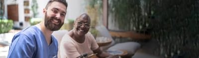 Resident and staff member smiling in a communal area