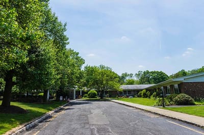 Tree-lined path leading to a senior care facility