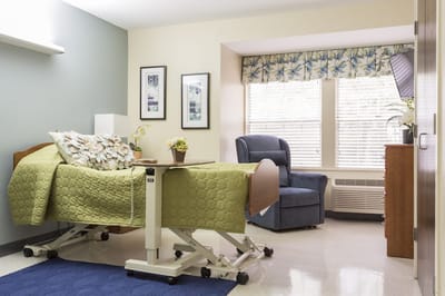 Private resident room with a bed and chair