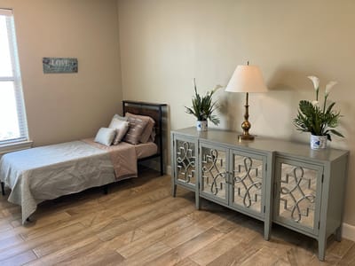 A well-decorated resident room with a bed and decorative furnishings.