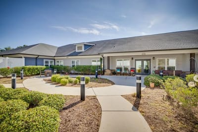 Exterior view of the assisted living facility with pathway and landscaping