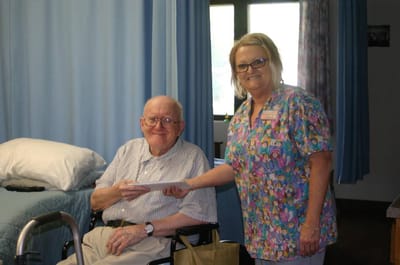 Staff member handing an envelope to a smiling resident