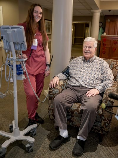 Staff member assisting a resident in a comfortable sitting area