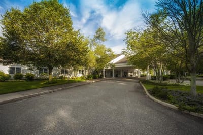 Entrance of Westhampton Care Center surrounded by greenery