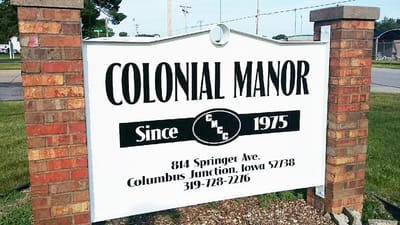 Outdoor sign of Colonial Manor with contact information