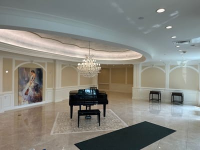 Interior view of a lobby with a grand piano and chandelier