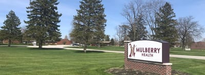 Exterior view of Mulberry Health facility sign with landscaping