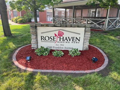 Exterior sign of Rose Haven Nursing Home with landscaping