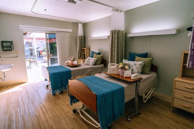 A well-lit shared room with two beds and decor