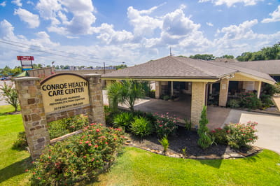 Exterior view of Conroe Health Care Center with landscaping