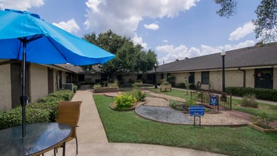 Outdoor garden space with seating and blue umbrella