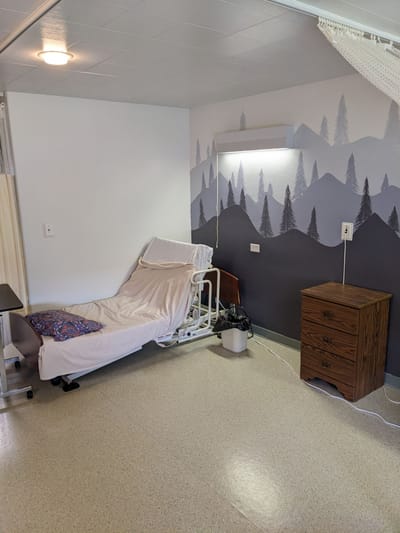 Interior view of a resident room with a bed and dresser