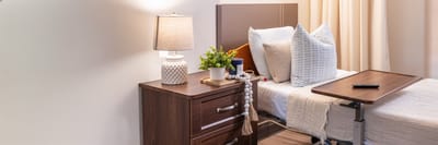 A neatly arranged resident room with bed and nightstand