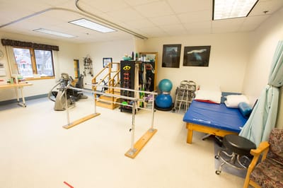 Physical therapy room with exercise equipment and mats