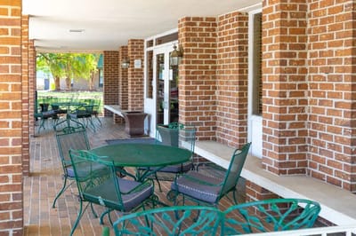 Outdoor seating area with green chairs and tables