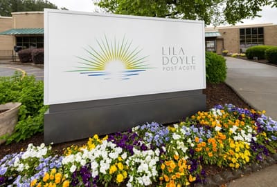Facility logo displayed outdoors with flowers