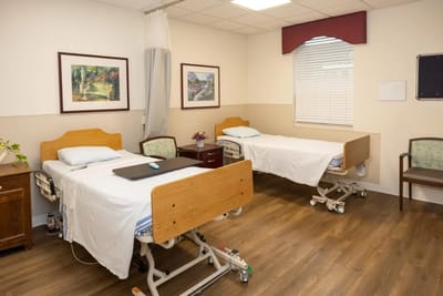 A shared resident room with two beds and artwork