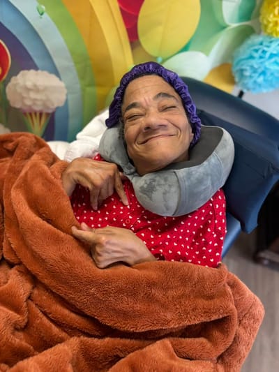 Resident enjoying a cozy moment in a bright room.