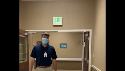 Staff member wearing a mask in the hallway.