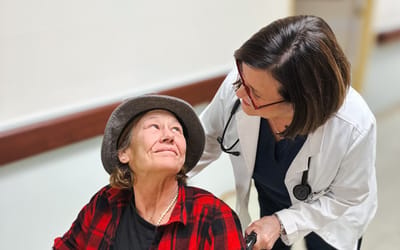 Caregiver interacting with a resident in a hallway.