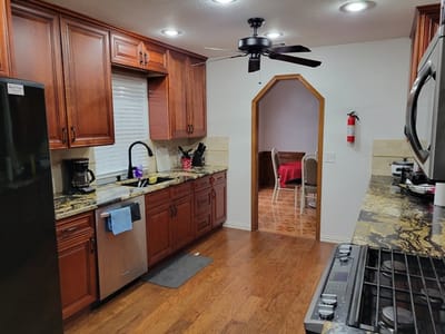 A kitchen area with wooden cabinets and granite countertops