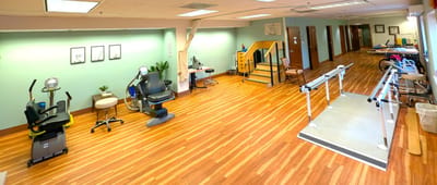 Therapy room with exercise equipment and wooden flooring
