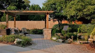 Paved outdoor path leading to a shaded seating area