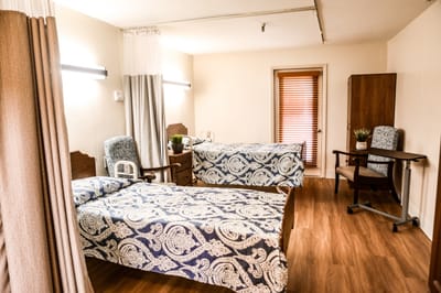 Private resident room with two beds and seating area